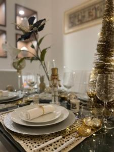 einen Tisch mit einer weißen Platte und Gläsern Wein in der Unterkunft Sea Elegance in Oliveri
