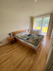 a bedroom with a bed and a wooden floor at Tomas Apartment in Cēsis