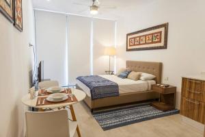 a bedroom with a bed and a table and a dining room at The City Condos Playa del Carmen in Playa del Carmen