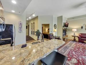 a kitchen with a sink and a living room at 377 Edgewater Inn in Charlevoix
