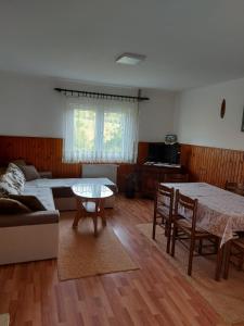 een woonkamer met een tafel en een bank bij Domaćinstvo Sindžirević in Nova Varoš