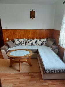 een woonkamer met een bed en een salontafel bij Domaćinstvo Sindžirević in Nova Varoš
