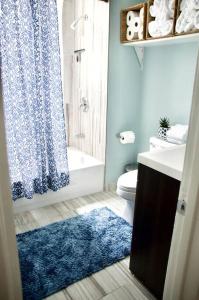 a bathroom with a blue shower curtain and a blue rug at Sunny, Spacious, 3BR 1BA Davlin INN Chicago in Chicago +24 photos