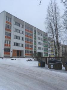 a large building with snow in front of it at Tomas Apartment in Cēsis