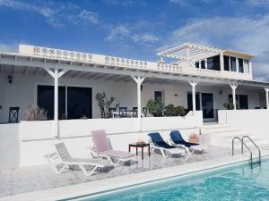 una casa con sillas y una piscina en Villa Nirvana - Casa Marosenia, en Güime