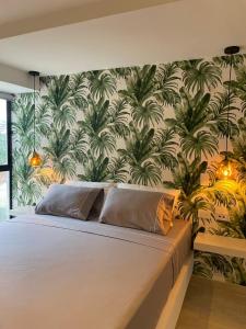 una camera da letto con un grande letto e carta da parati tropicale di Hotel 14-04 a Cali