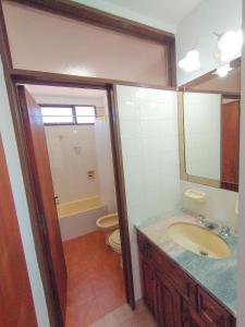 uma casa de banho com um lavatório, um WC e um espelho. em Depto Las Heras em Villa Carlos Paz