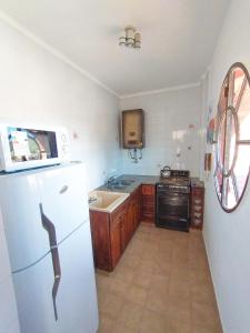 uma cozinha com um frigorífico branco e um lavatório em Depto Las Heras em Villa Carlos Paz