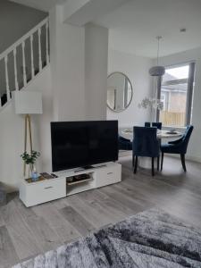 a living room with a flat screen tv and a table at Bronallt luxury in Mountain Ash