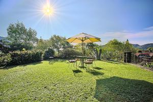 a table and chairs with an umbrella in a yard at Casa Jacobina Tepoztlán in Tepoztlán
