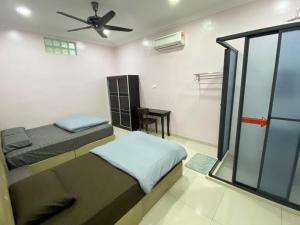 1 Schlafzimmer mit 2 Betten und einem Deckenventilator in der Unterkunft Sekinchan 71 Landed PaddyView House 16pax Wifi in Kampong Sungai Leman