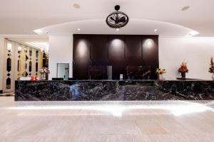 a lobby with a black marble counter and chairs at โฮเทลมุก in Mukdahan