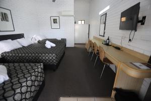 a room with two beds and a table and chairs at The Town House Motor Inn in Goondiwindi
