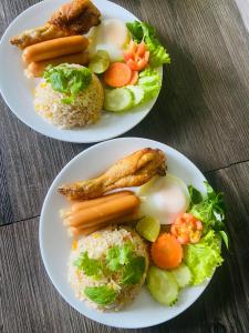 Pakor Boutique Resort في فانجنجا: طبقين من الطعام مع الأرز واللحوم والخضروات
