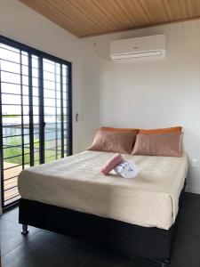 une chambre avec un grand lit avec une grande fenêtre dans l'établissement La Sifrina Punta Negra, à Punta Colorada