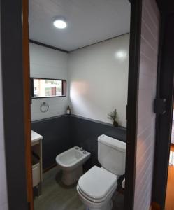 a bathroom with a white toilet and a sink at Cantal Tiny house in Salta