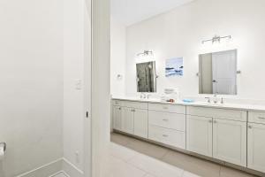 a white bathroom with two sinks and a mirror at Family Tides in Santa Rosa Beach +28 photos