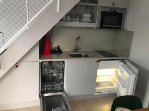 a small kitchen with a sink and an open refrigerator at Avanti Apartment Hotel in Stockholm