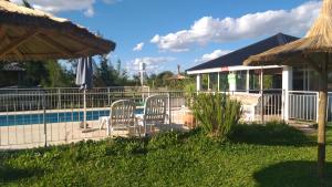 un grupo de sillas sentadas junto a una piscina en Los manzanos . en Colón