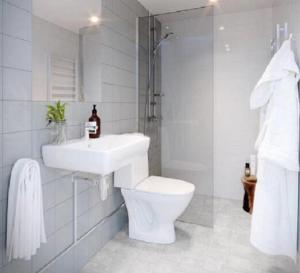 a white bathroom with a sink and a toilet at Avanti Apartment Hotel in Stockholm
