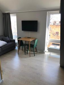 a living room with a table and a tv at Avanti Apartment Hotel in Stockholm