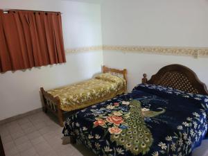 een slaapkamer met een bed en een stoel bij El Remanso Estadia Minima 2 Noches in Cordoba