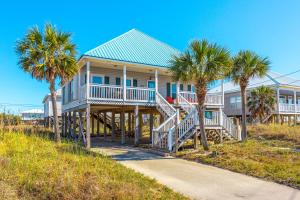 a house on the beach with palm trees at Ripplin Sands in Dauphin Island