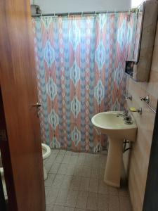 een badkamer met een wastafel, een toilet en een douchegordijn bij El Remanso Estadia Minima 2 Noches in Cordoba