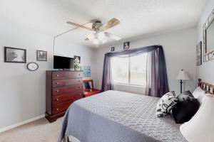 a bedroom with a bed and a dresser and a window at Plantation East #1104 in Gulf Highlands +30 photos