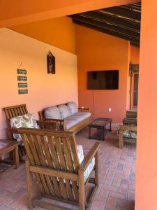 a living room with a couch and a tv at Vila Rica Xangri-lá - 550 Metros do Mar in Xangri-lá