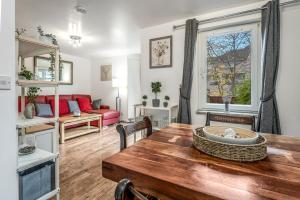 a living room with a table and a couch at Spacious 3 Bedroom Modern House - Heart of Edinburgh - Private Main Door Entrance & Private Garden with Stunning Views of Arthur Seat in Edinburgh