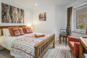 1 dormitorio con 1 cama, 1 silla y 1 ventana en Spacious 3 Bedroom Modern House - Heart of Edinburgh - Private Main Door Entrance & Private Garden with Stunning Views of Arthur Seat, en Edimburgo