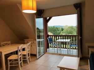 - une salle à manger avec un balcon doté d'une table et de chaises dans l'établissement Résidence La Ferme de Deauville - Saint Arnoult, à Saint-Arnoult