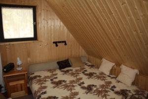 A bed or beds in a room at Szarvaskő Szérűskert vendégház