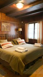 Un dormitorio con una cama grande con toallas. en El Barquito, en San Martín de los Andes
