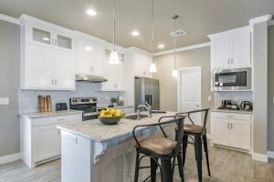 una cocina con armarios blancos y un bol de fruta en una barra en Beautifully Decorated New Home, King Bed, Washer/Dryer & Fully Stocked Kitchen, en Canyon