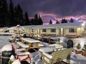 a building covered in snow with tables and chairs at Travel Inn in South Lake Tahoe