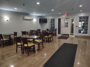 a dining room with tables and chairs in a restaurant at Hilltop Inn & Suites - North Stonington in North Stonington