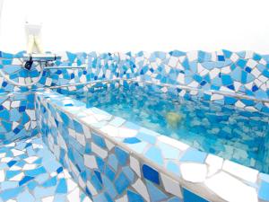 a swimming pool with blue and white tiles at Pension Buddy in Kitashiobara