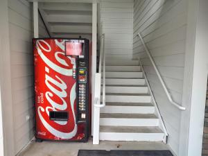 a coca cola vending machine next to a staircase at Hilltop Inn & Suites - North Stonington in North Stonington