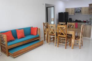 ein Wohnzimmer mit einem Sofa, einem Tisch und Stühlen in der Unterkunft Mar y Tierra in Coveñas