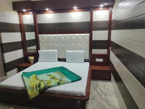 a bedroom with a bed in a room with striped walls at Vidya Guest House in Katra