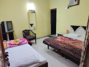 a hotel room with two beds and a tv at Vidya Guest House in Katra