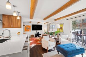 a kitchen and living room with white walls and wooden ceilings at 700 Monarch 201 in Aspen +33 photos