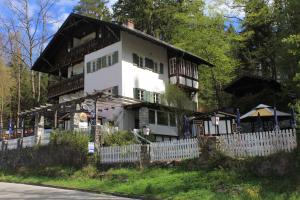 una casa con una cerca blanca delante de ella en Pension Steakhaus Füssen, en Füssen