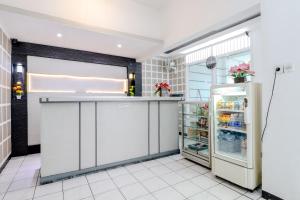 a kitchen with a refrigerator and a counter at Hotel Bintang in Malang