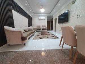 a living room with a couch and chairs and a television at شاليه الشهد in Ma‘ābīlah