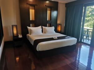 1 dormitorio con cama grande y ventana grande en Yodia Heritage Hotel en Phitsanulok