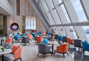 蘇州的住宿－苏州尼依格罗酒店，餐厅设有桌椅和大窗户。
