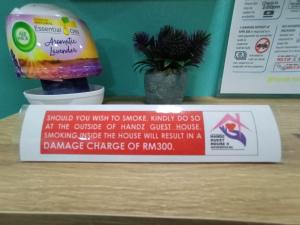 a sign sitting on a table with a pineapple at The Handz House II with WIFI - For family or same gender only in Kepala Batas